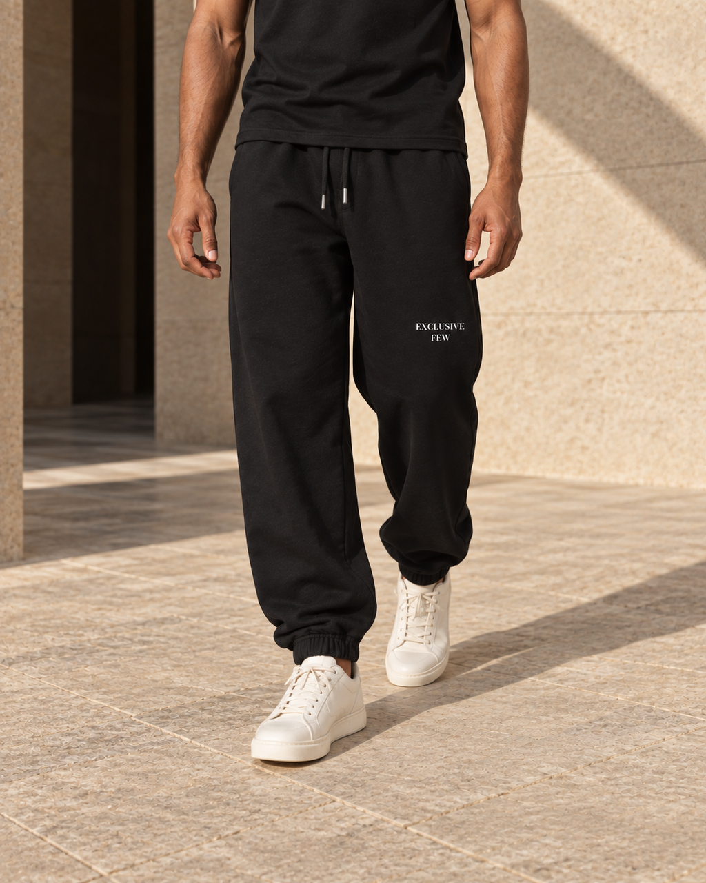 Black Urban Baggy Sweatpants shown on a model in motion, with cuff and drawcord details.